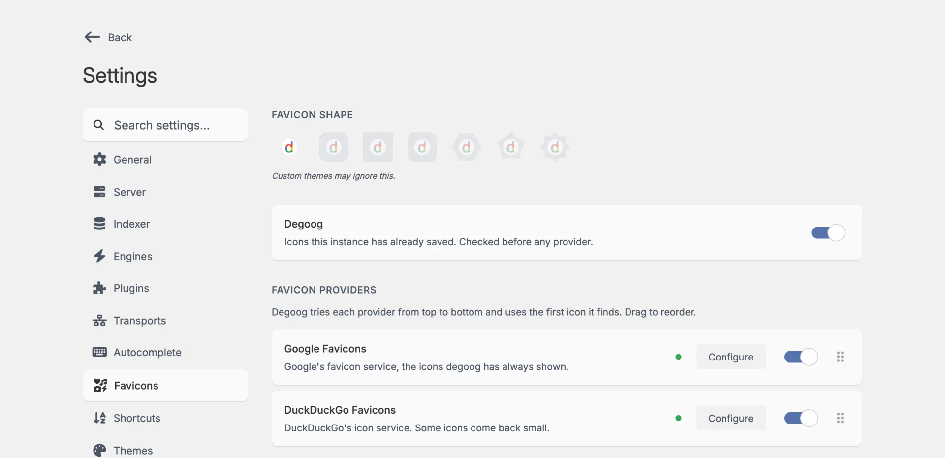 The Favicons tab. A row of seven favicon shapes with the note 'Custom themes may ignore this.' Below it a Degoog card that is switched on, then Google Favicons and DuckDuckGo Favicons, each with a Configure button, a switch and a drag handle.